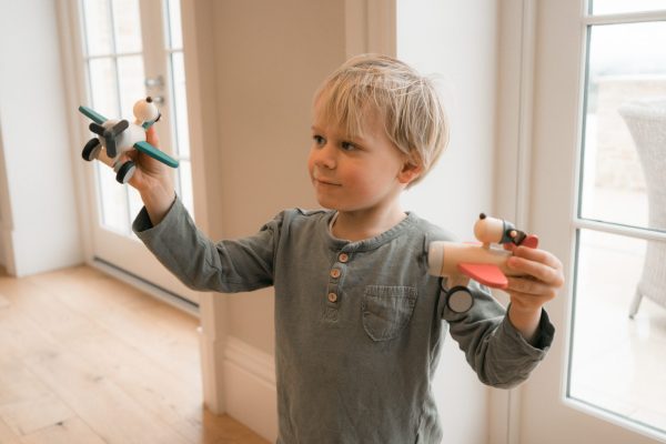 boy playing with toy wooden planes